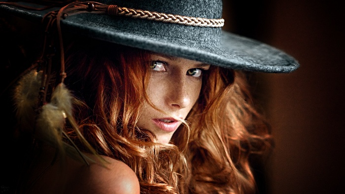 Portrait of a redhead woman with freckles wearing a hat
