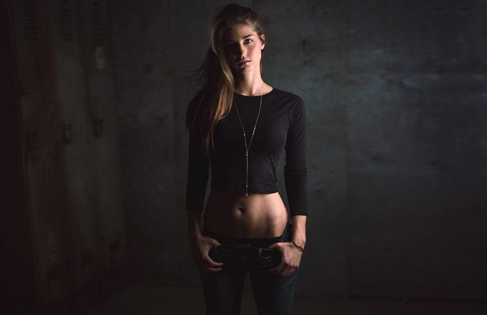 Woman with long brown hair wearing a black crop top