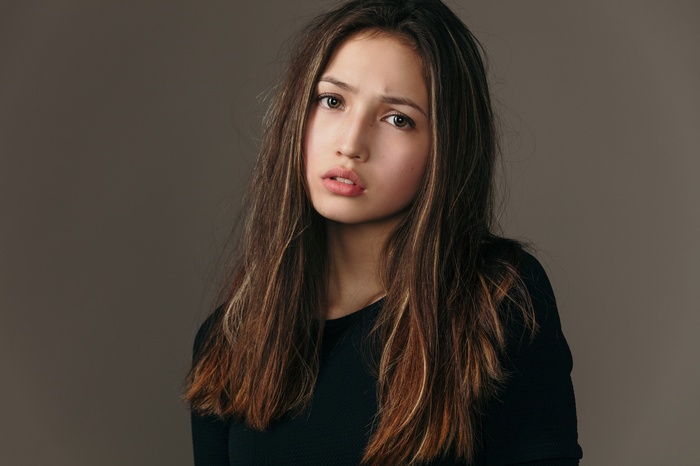 Young woman with long brown hair in a black shirt
