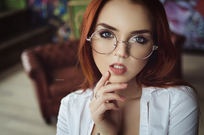 Redhead woman with glasses in a white shirt