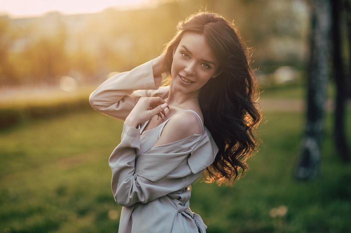 Woman smiling outdoors with sunlit hair