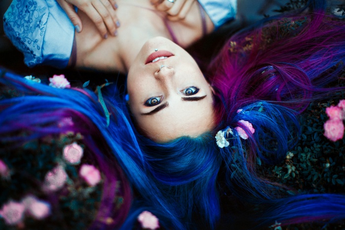 Woman with blue and purple dyed hair lying down