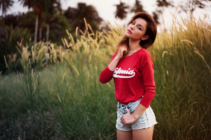 Woman in red shirt and jean shorts outdoors
