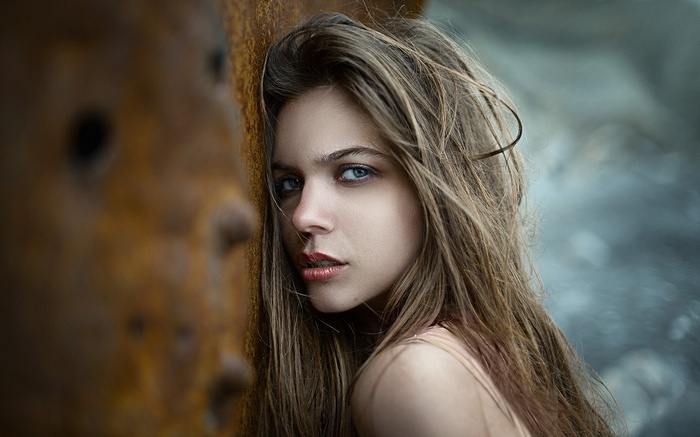 Woman leaning against rusty metal, portrait
