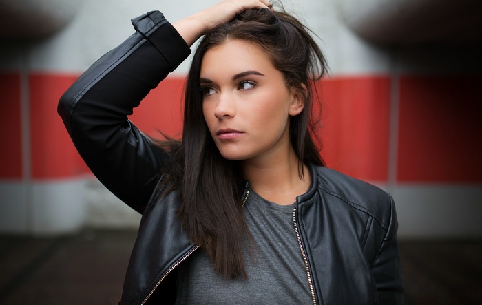 Woman with hand in hair wearing leather jacket