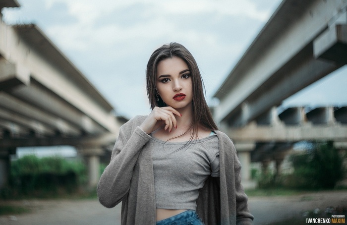Woman in sweater and jeans under bridge