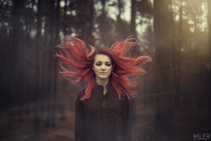 Woman with red hair in a forest