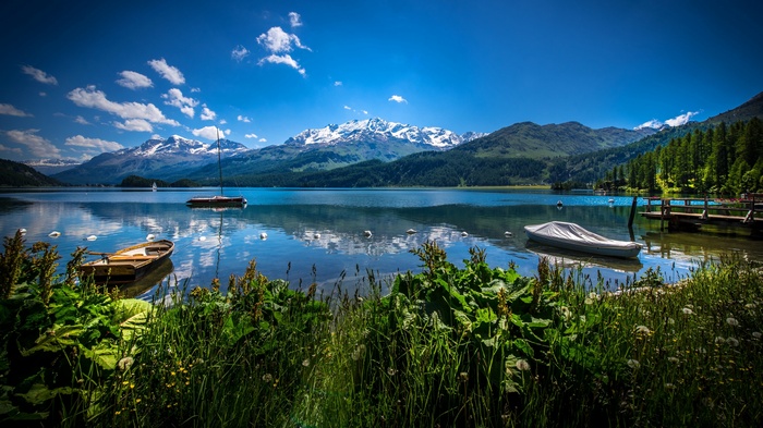 Lake with boats and snow-capped mountains