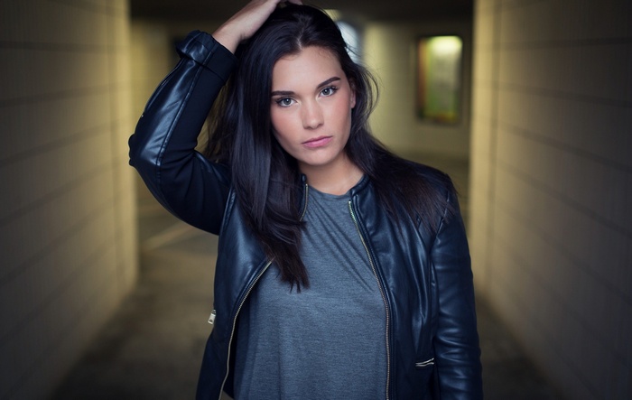 Woman in leather jacket with hand on head