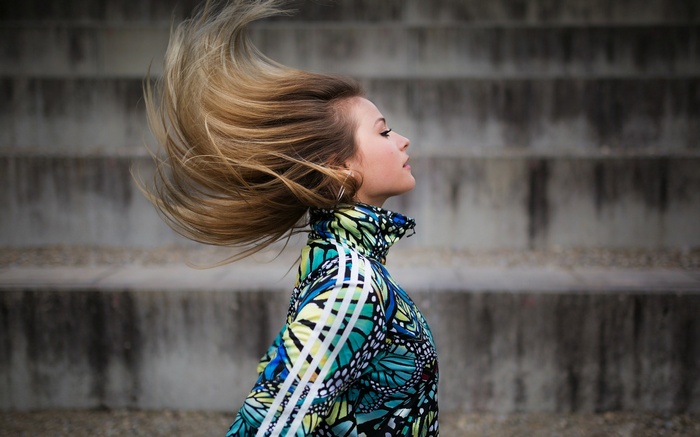 Woman with windblown hair wearing a butterfly jacket