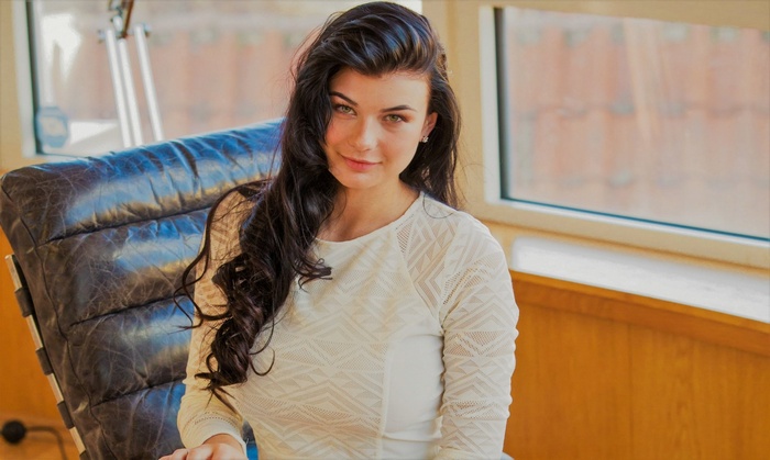 Woman with long dark hair sitting in a chair