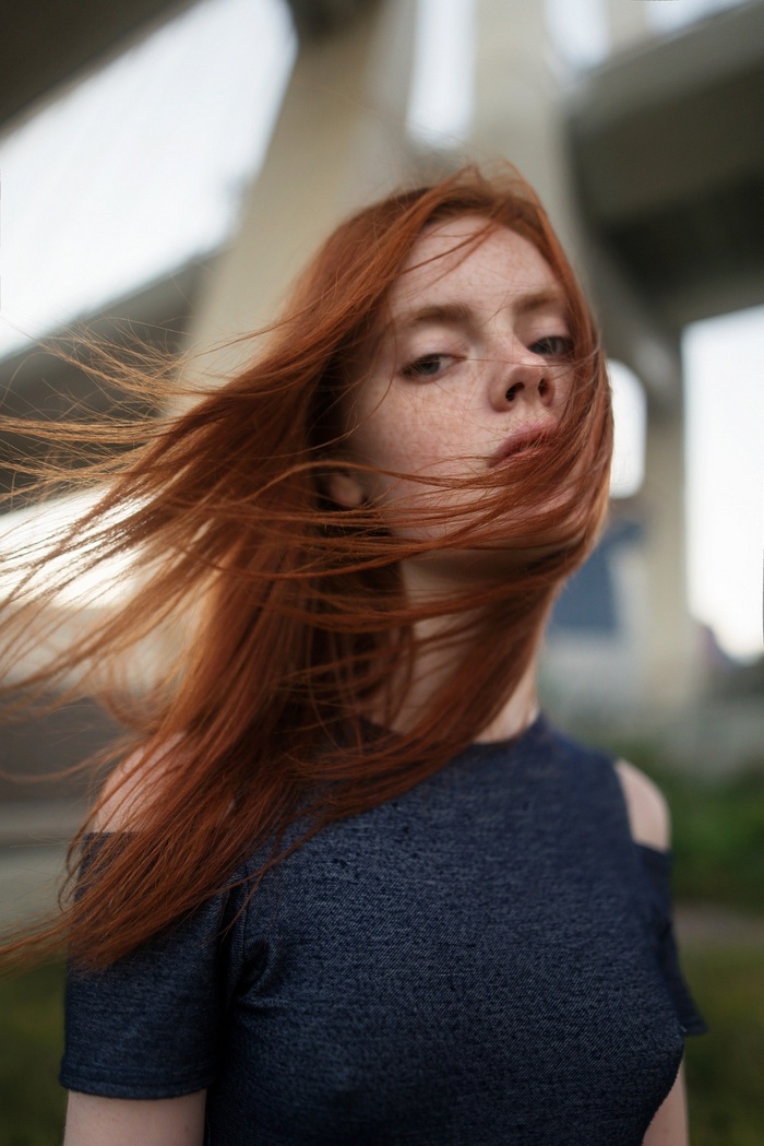 Redhead woman with freckles and hair in face