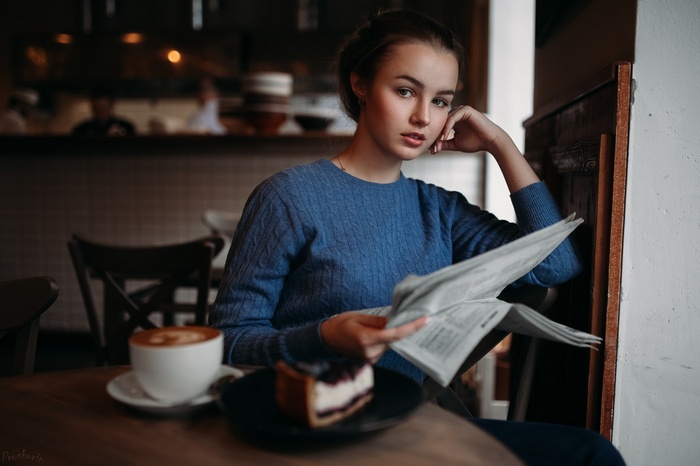 Julia Tavrina reading a newspaper in a cafe