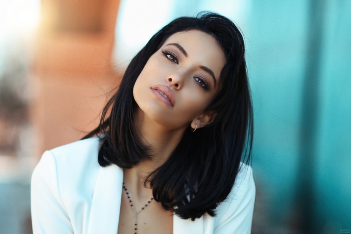 Woman with black hair and white jacket
