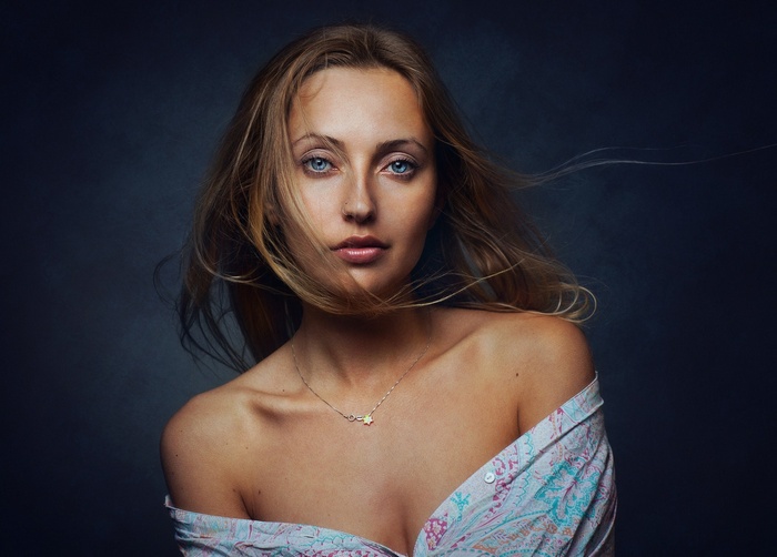 Woman with windblown hair and off-the-shoulder shirt