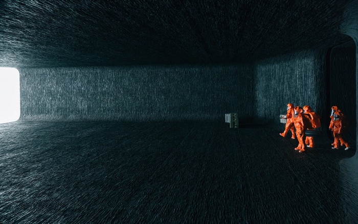 Figures in Hazmat suits in a dark room