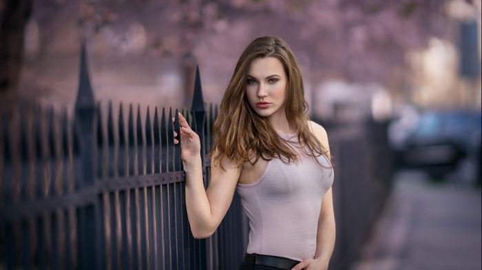 Nikol model leaning on a fence