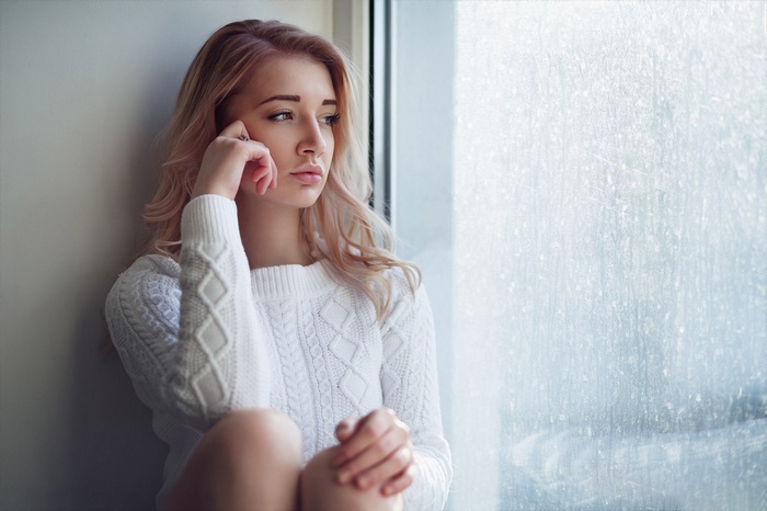 Woman in white sweater by the window