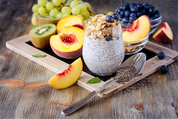 Chia seed pudding with granola, blueberries, peaches, kiwi, and grapes