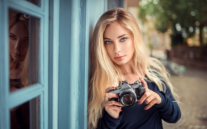 Woman with blonde hair holding a camera