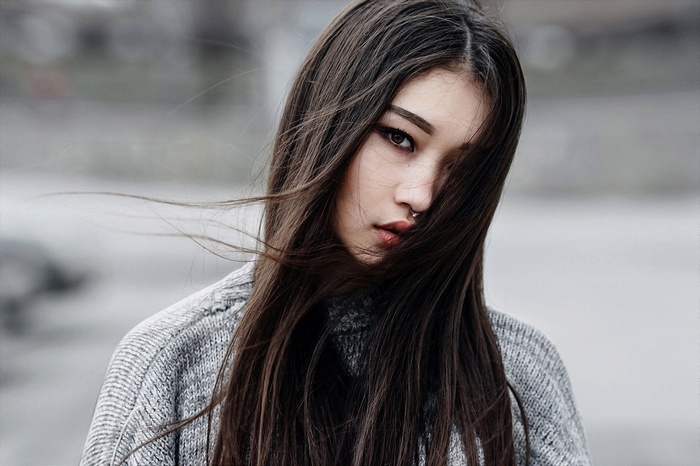 Portrait of a young woman with dark hair and a nose ring