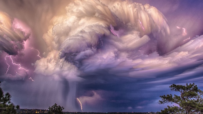 Lightning strikes through dramatic storm clouds over a landscape