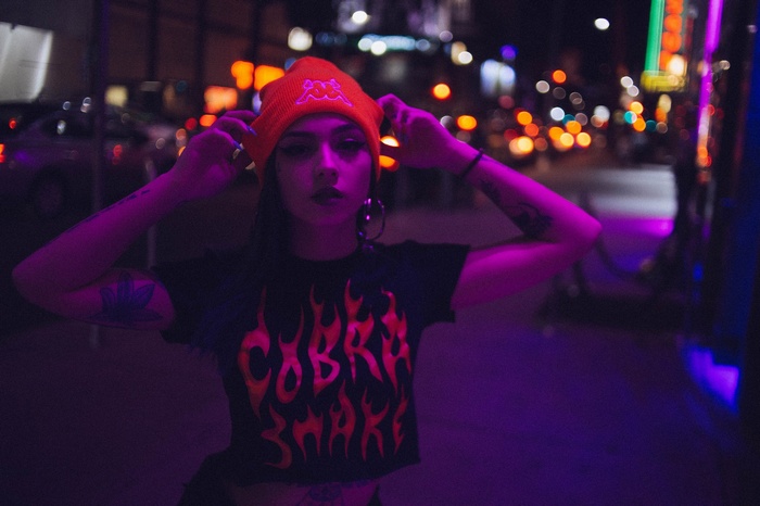 Woman in orange beanie and flame t-shirt at night