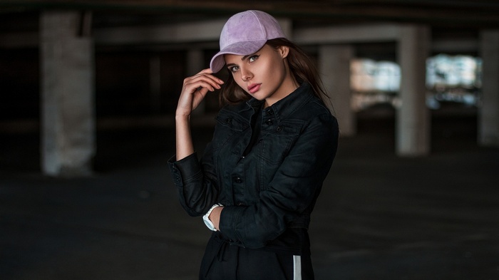 Woman wearing a baseball cap and denim jacket