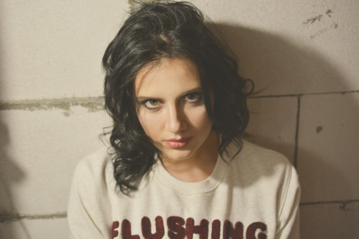 Young woman with black curly hair in a sweatshirt