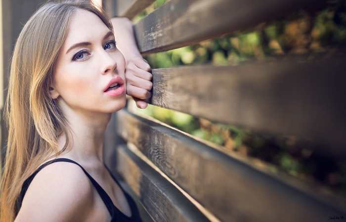 Woman leaning on a wooden fence