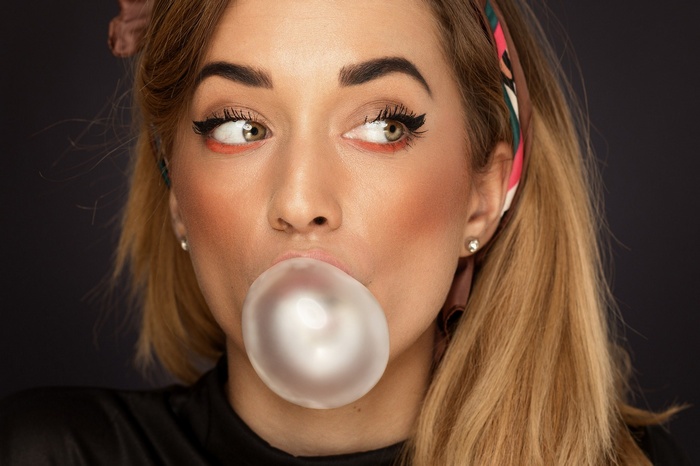 Woman blowing a large bubblegum bubble