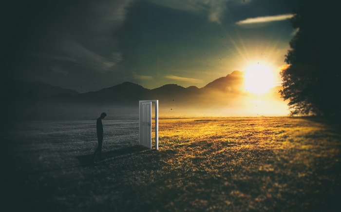 Man walks through a door from darkness to sunlight
