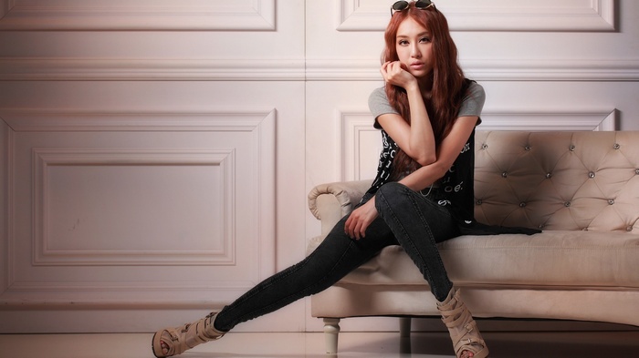 Asian woman with long hair sitting on a couch