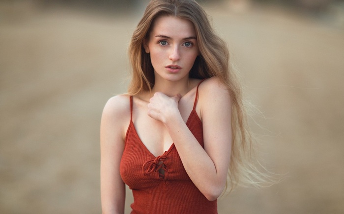 Woman with long blonde hair wearing a red top