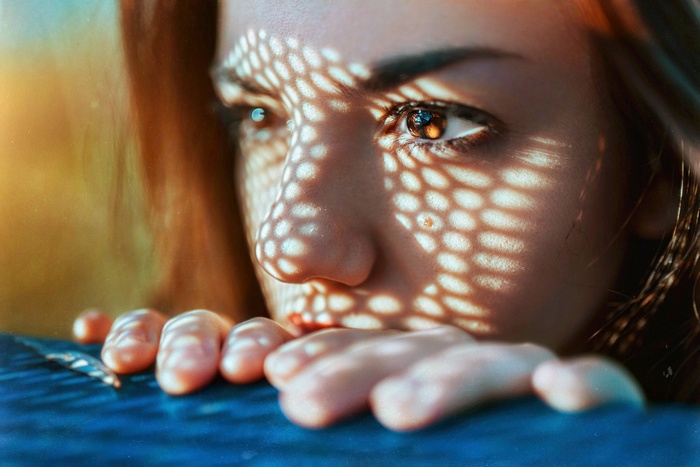 Woman with patterned light on her face and hands
