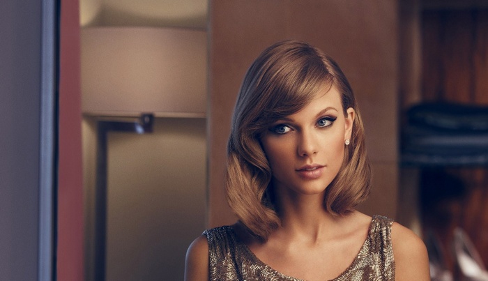Taylor Swift with blonde hair and pearl earrings