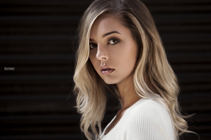 Woman with blonde hair in a white top