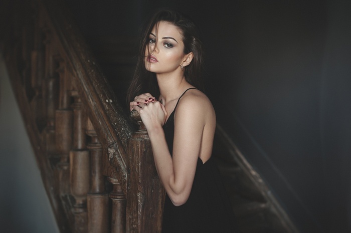 Woman in black dress on wooden stairs