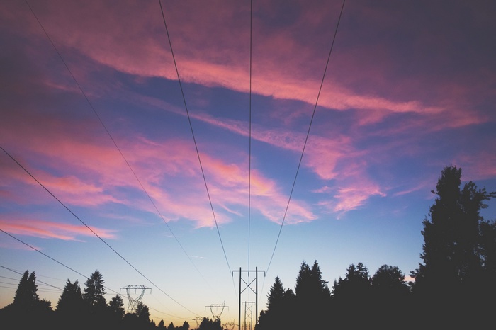 Power lines against a sunset sky with clouds
