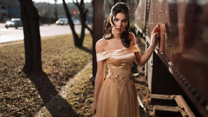 Woman in a golden dress by a train