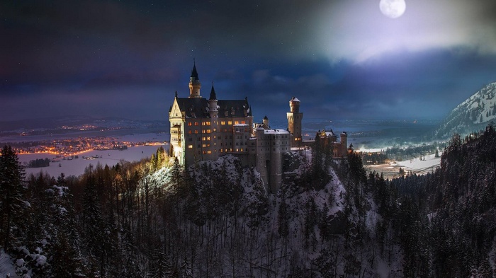 Neuschwanstein Castle at night with moon and snow