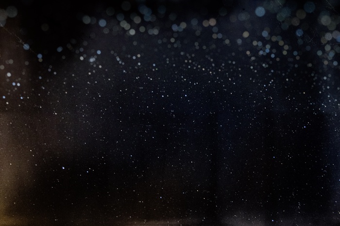 Dark background with scattered stars and bokeh lights