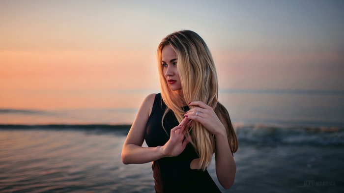 Woman with blonde hair at sunset by the sea