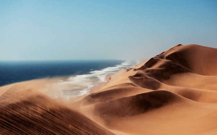 Sand dunes meeting the ocean in Namibia