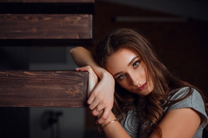 Woman resting her head on wooden stairs