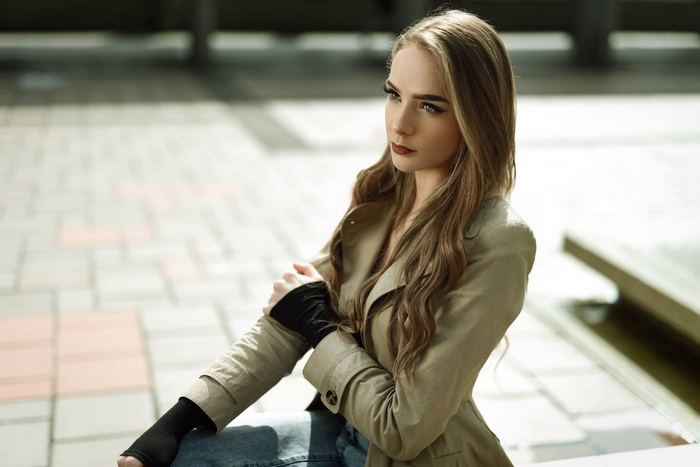 Woman with blonde hair wearing a trench coat