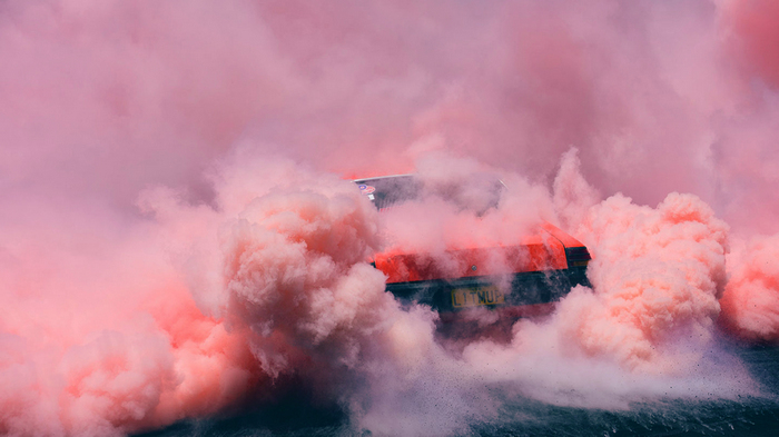 Red car in pink smoke