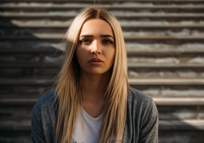 Woman with blonde hair in a grey cardigan
