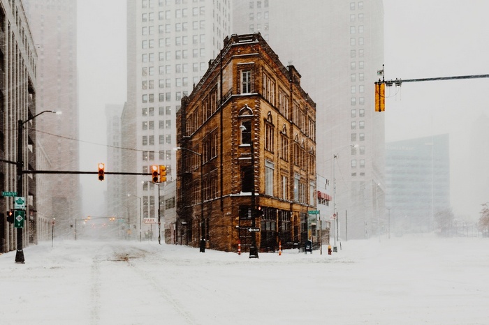 Snowy street in Detroit with traffic lights and buildings