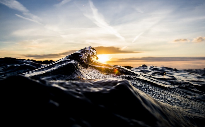 Wave cresting at sunset over the sea
